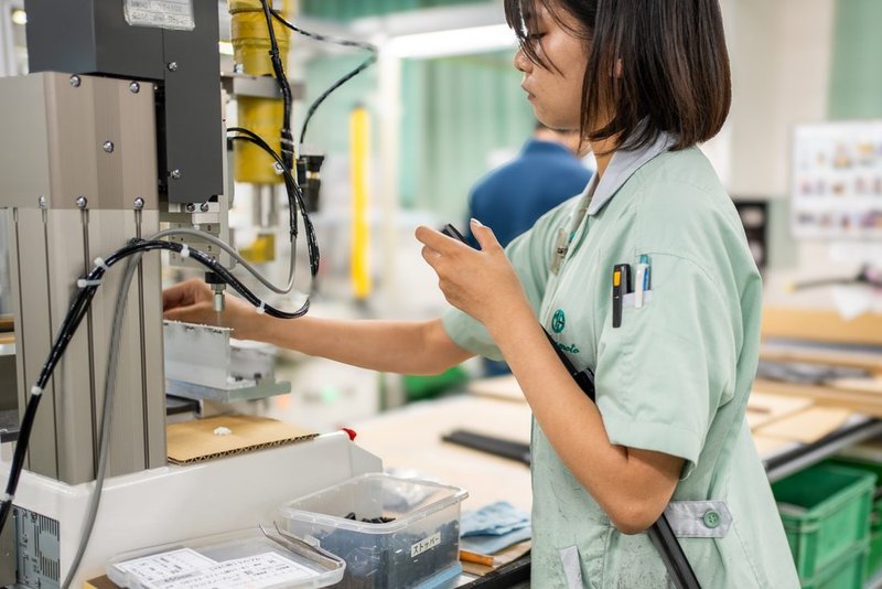 機械に部品をセットする社員
